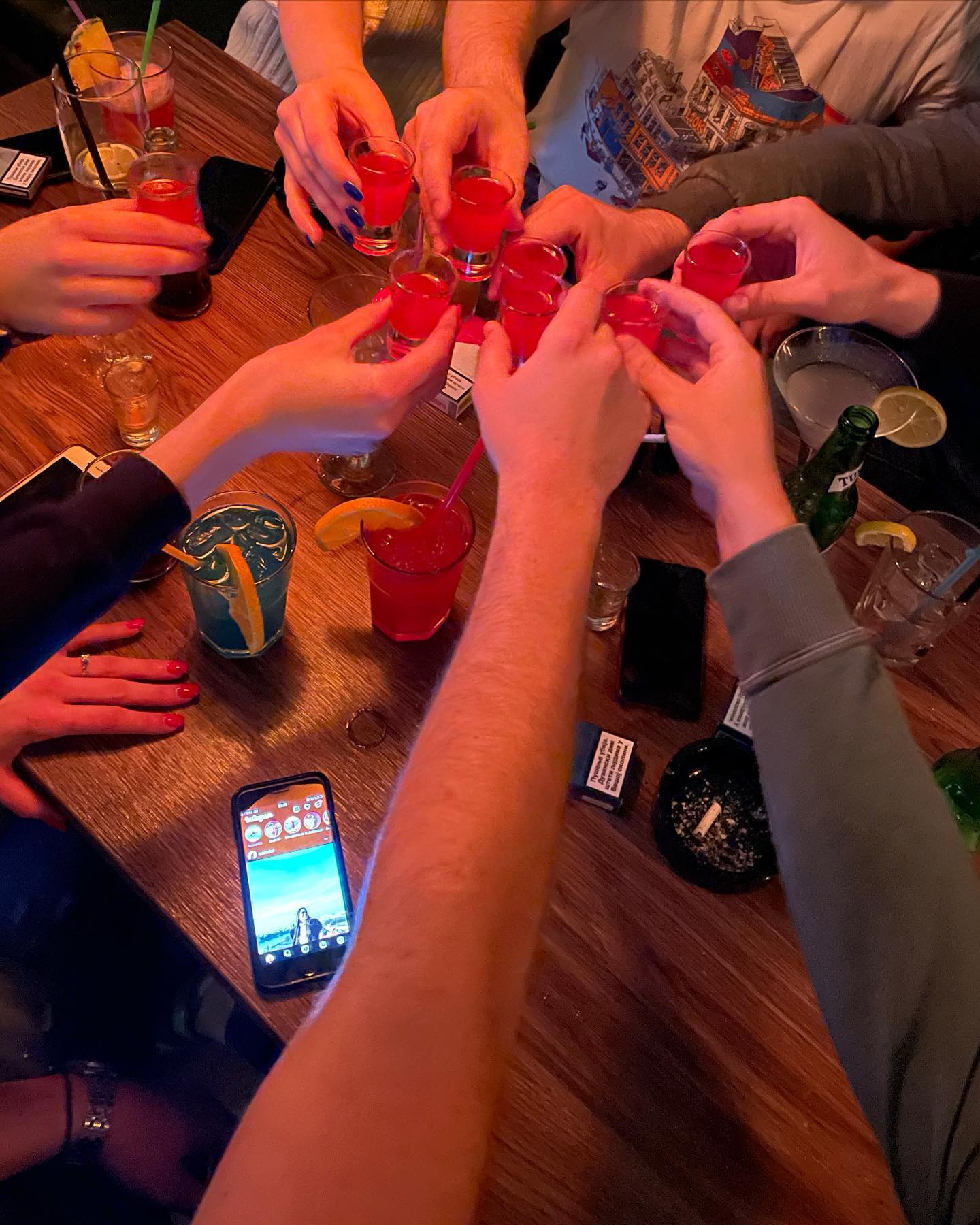A group of friends toasting with shots, enjoying the vibrant atmosphere of the restaurant.