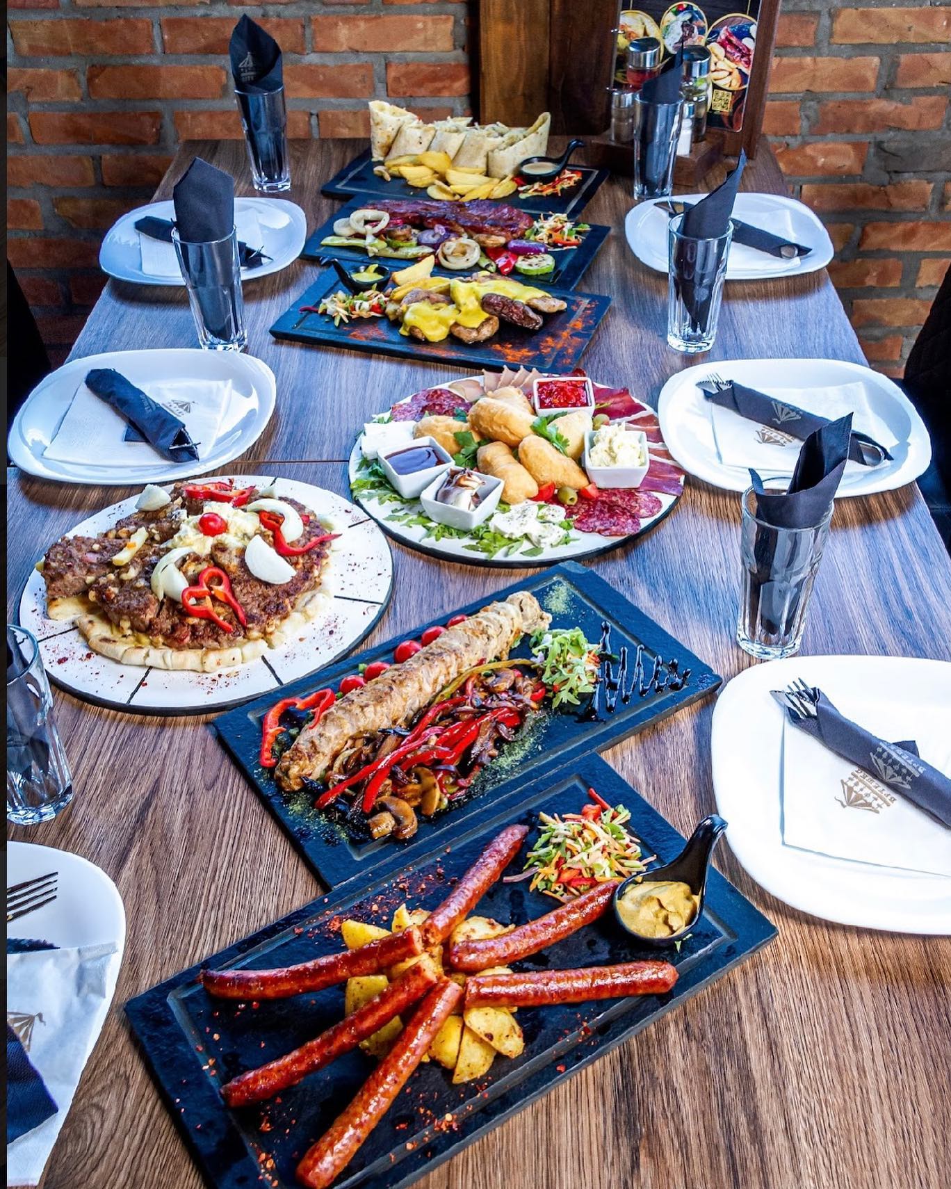 A large table filled with various traditional Serbian dishes at Vrteska Restoran.